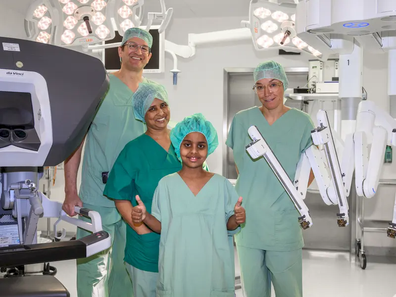 Kind und seine Mutter sind glücklich über die erfolgreiche Operation mit dem OP-Roboter durch Dr. Gerbershagen und Dr. Vatlach