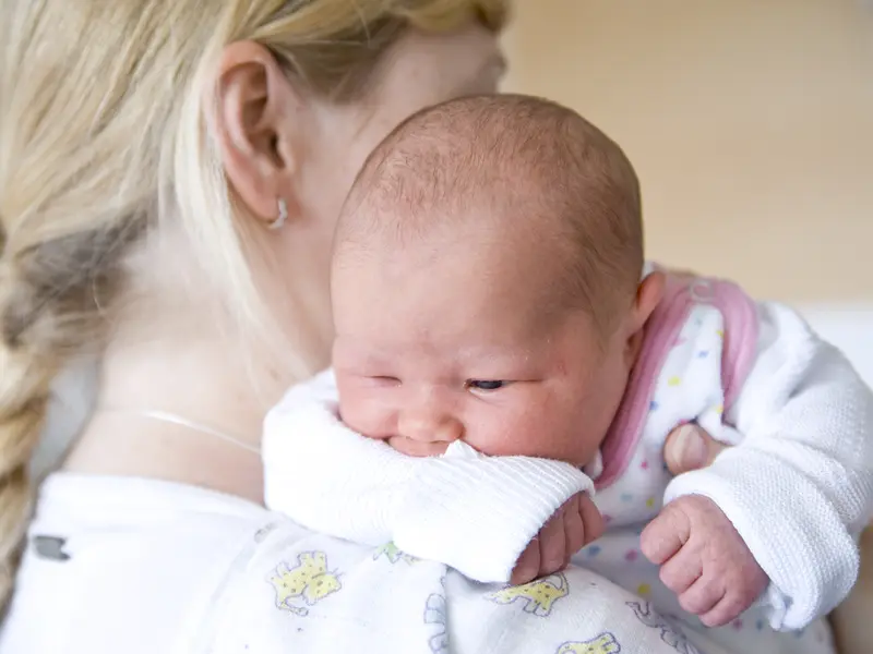 Neugeborenes Baby auf der Schulter der Mutter 