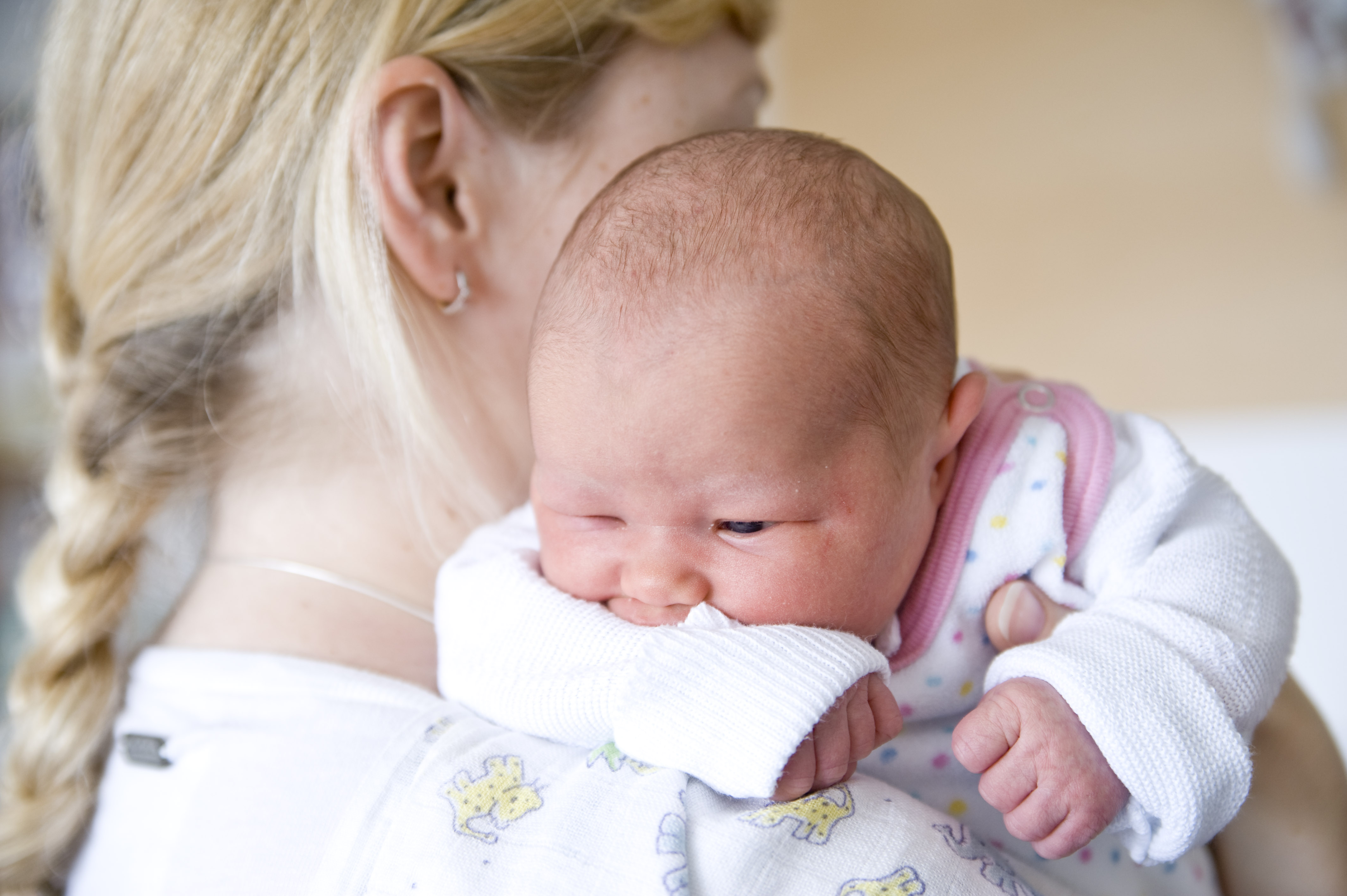 Neugeborenes Baby auf der Schulter der Mutter 